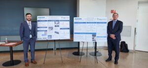 Students stand in front of presentation on two stands.